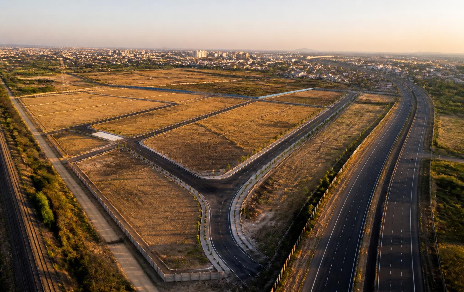Aerial view of vacant industrial land parcels beside a highway